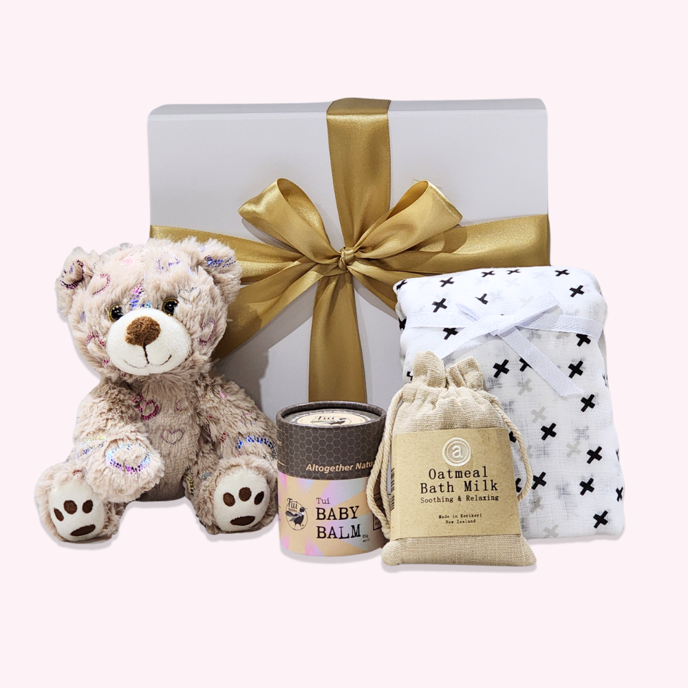 Cuddly Baby Teddy Bear gift set with baby essentials for soothing and comfort, including a muslin swaddle and bath milk.