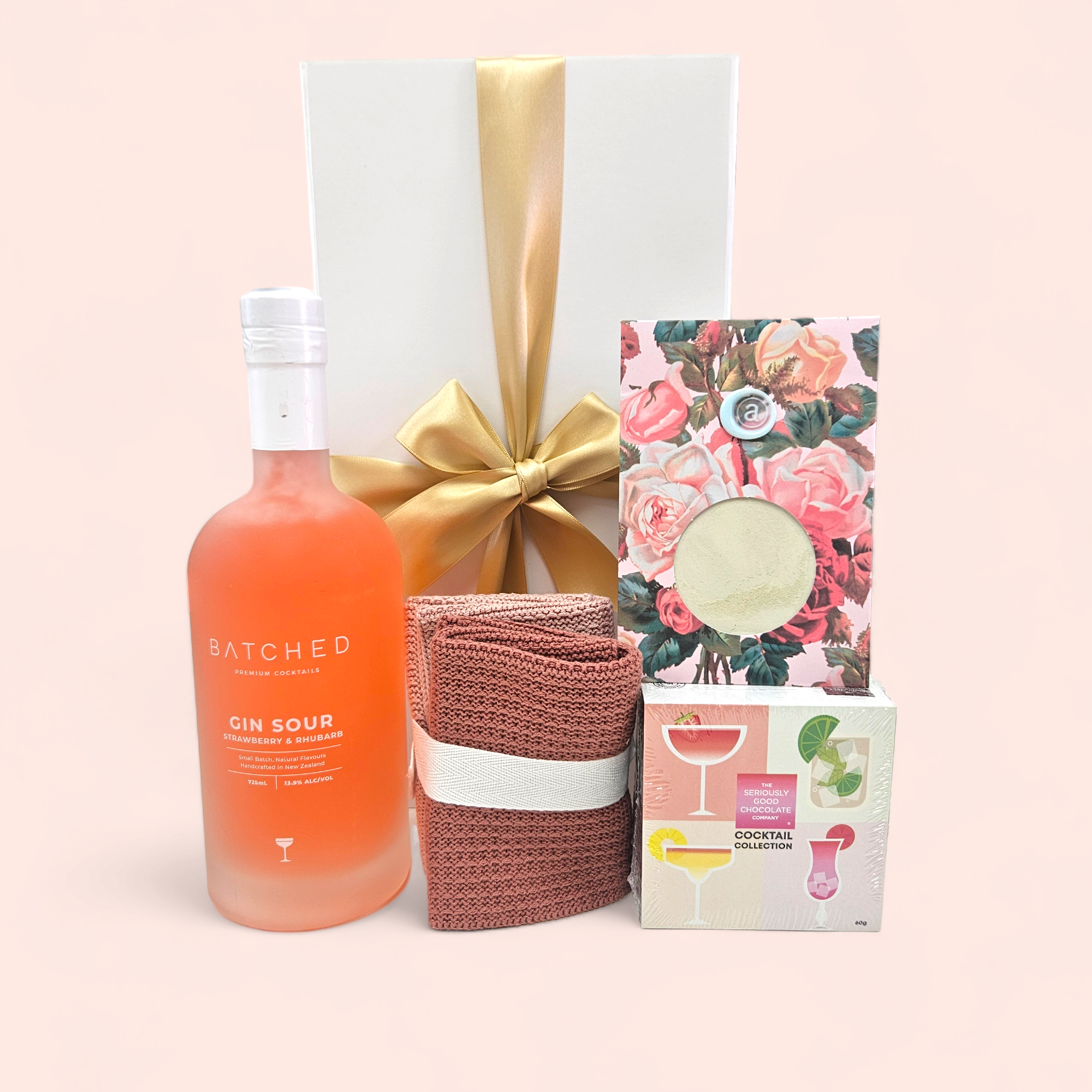 Luxurious Wind Down gift box featuring cocktails, eco-friendly facecloths, gourmet chocolates, and skincare goodies.