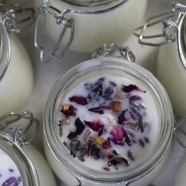 Anoint Aromatherapy Soy Candle featuring essential oils, crystals, and floral decor for a serene, calming atmosphere.