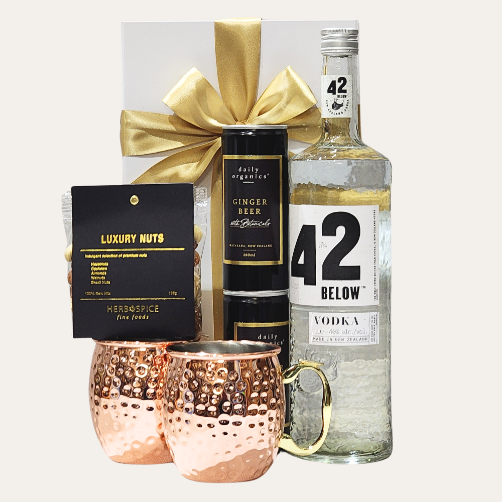 Moscow Mule Kit featuring 42 Below Vodka, mugs, ginger beer, nuts in an elegant gift box for a delightful cocktail experience.