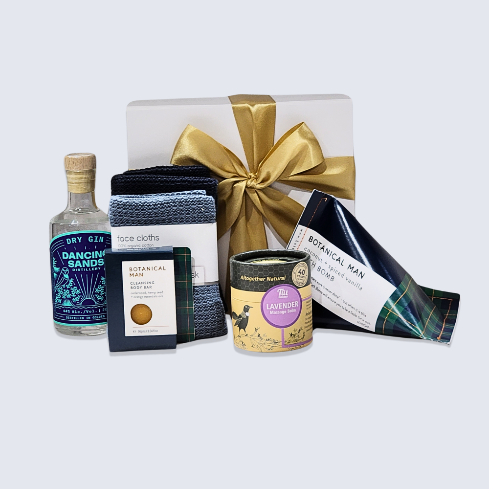 Elegant gift box for men featuring gin, massage balm, cleansing bar, bath bomb, and eco-friendly facecloths.