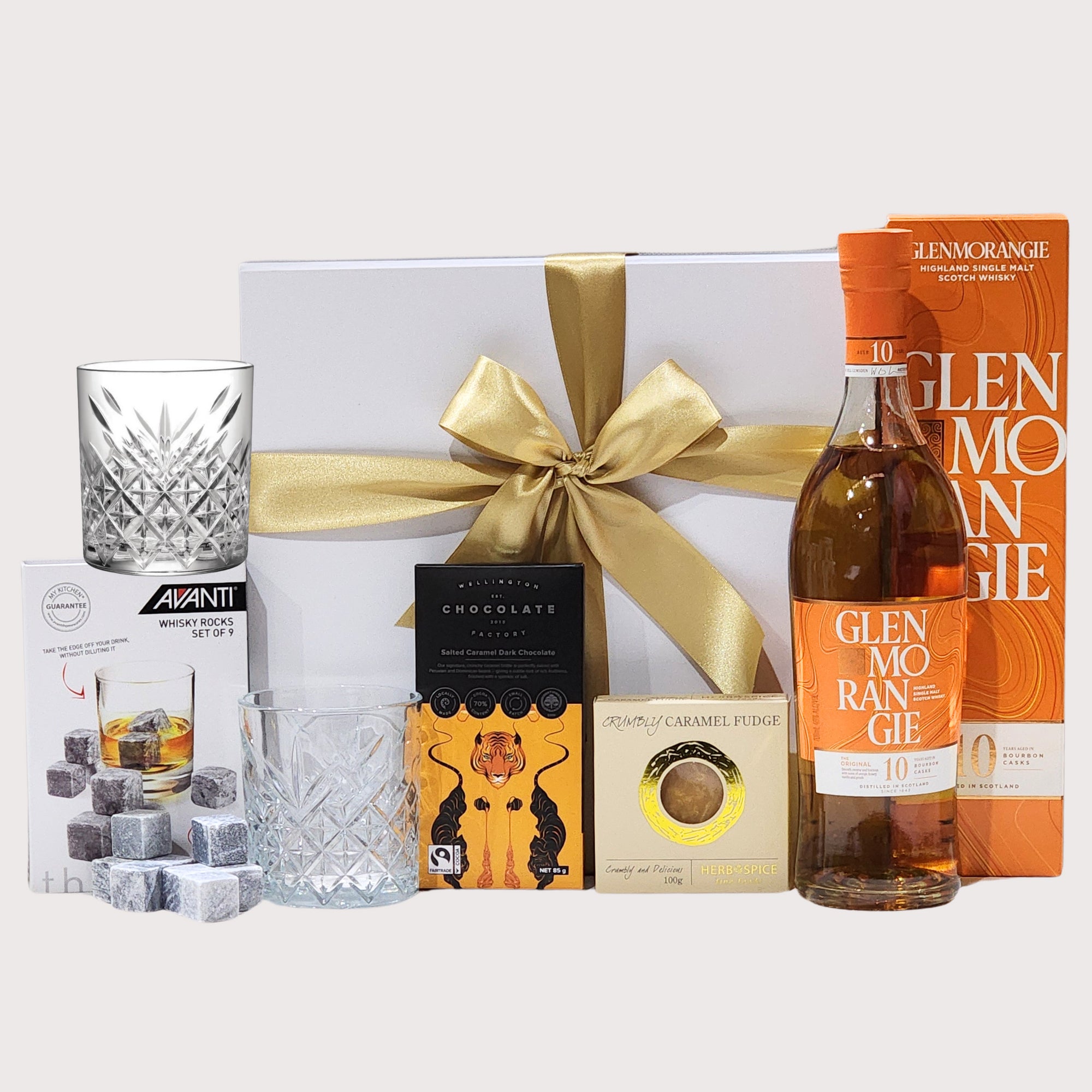 Elegant Glenmorangie whiskey gift set with glasses, rocks, chocolate, and fudge in a luxurious magnetic box.