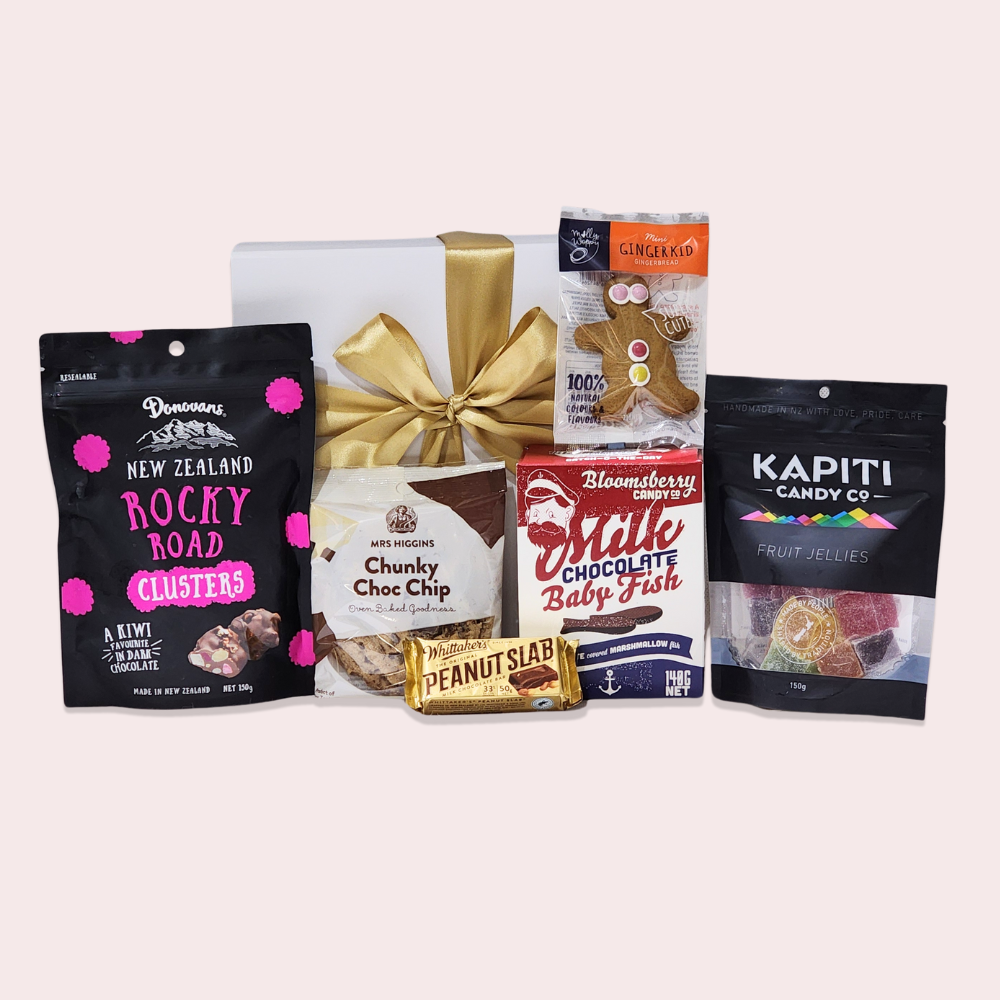 Colorful gift box featuring gourmet kids' treats like cookies, chocolate fish, and fruit jellies, perfect for special occasions.