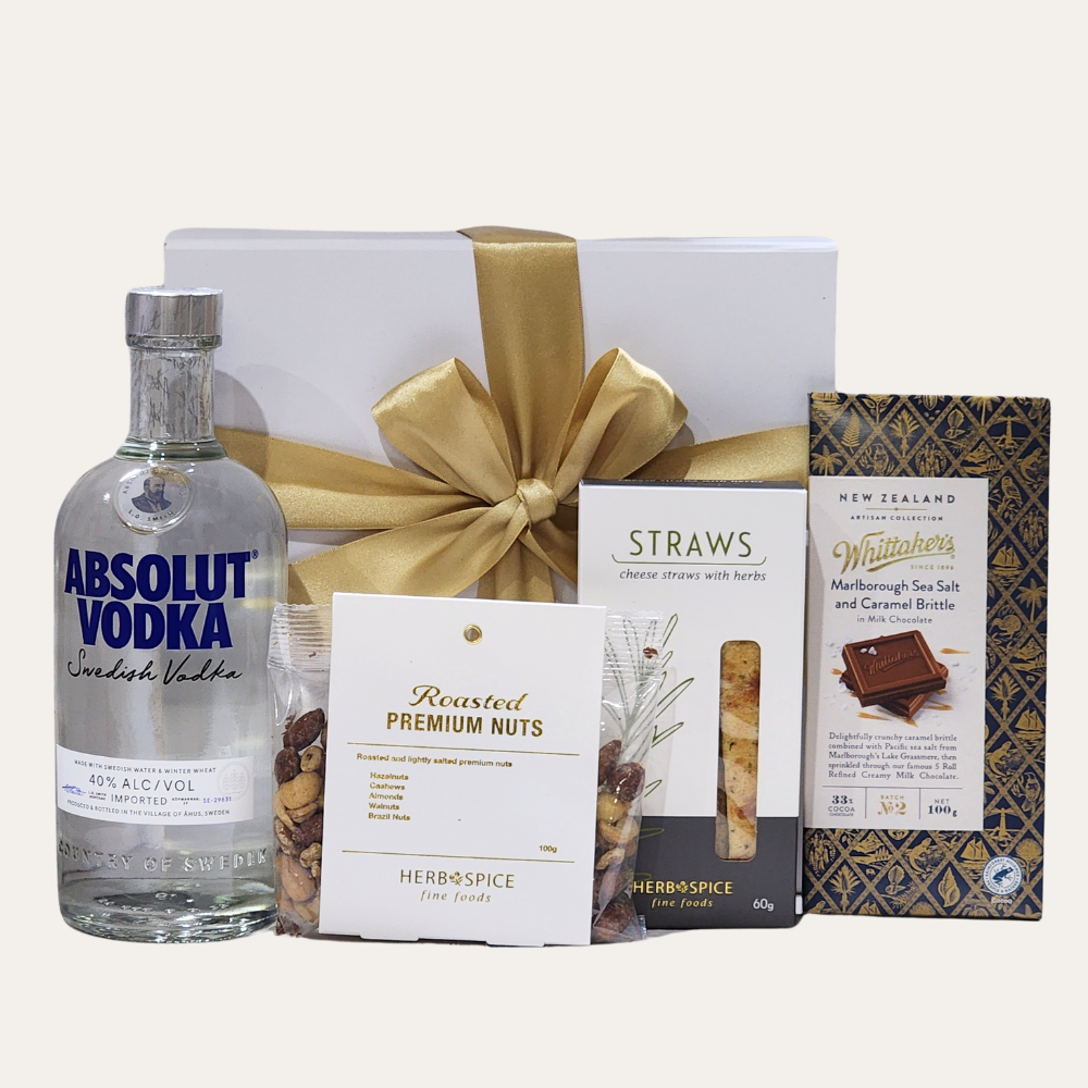 Luxurious gift set featuring Absolut Vodka, gourmet snacks, and rich chocolate, beautifully presented in an elegant box.