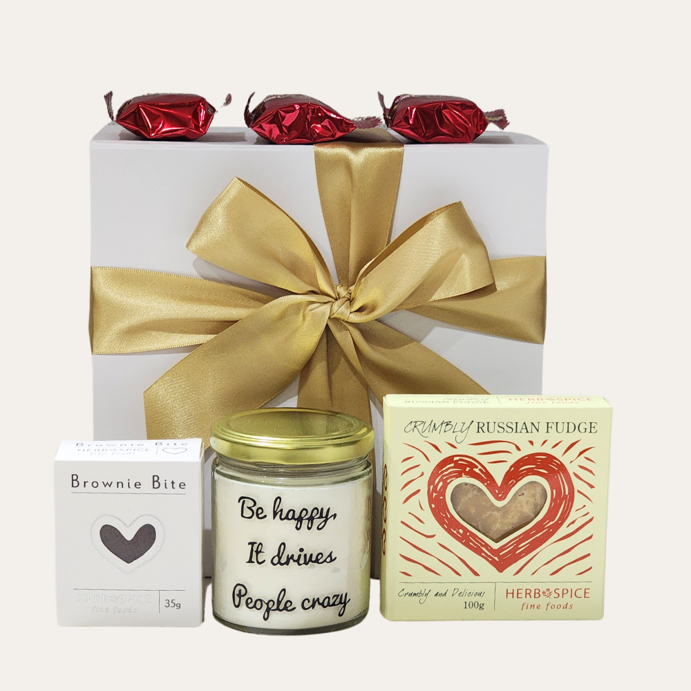 Gift box featuring a scented candle, brownie bites, fudge, and assorted treats designed to spread joy and elevate celebrations.