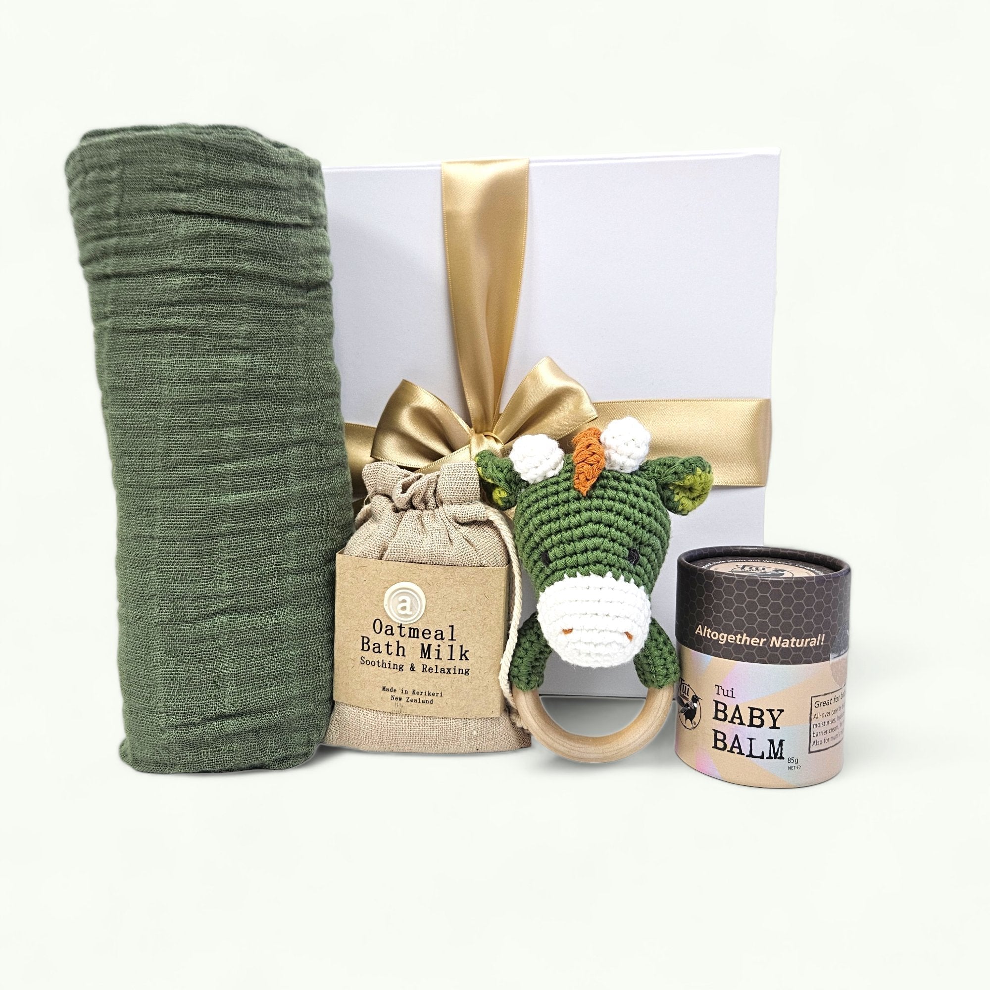 Cuddly Baby - Dino gift box features essential baby items for comfort, including a swaddle, rattle, and bath milk.