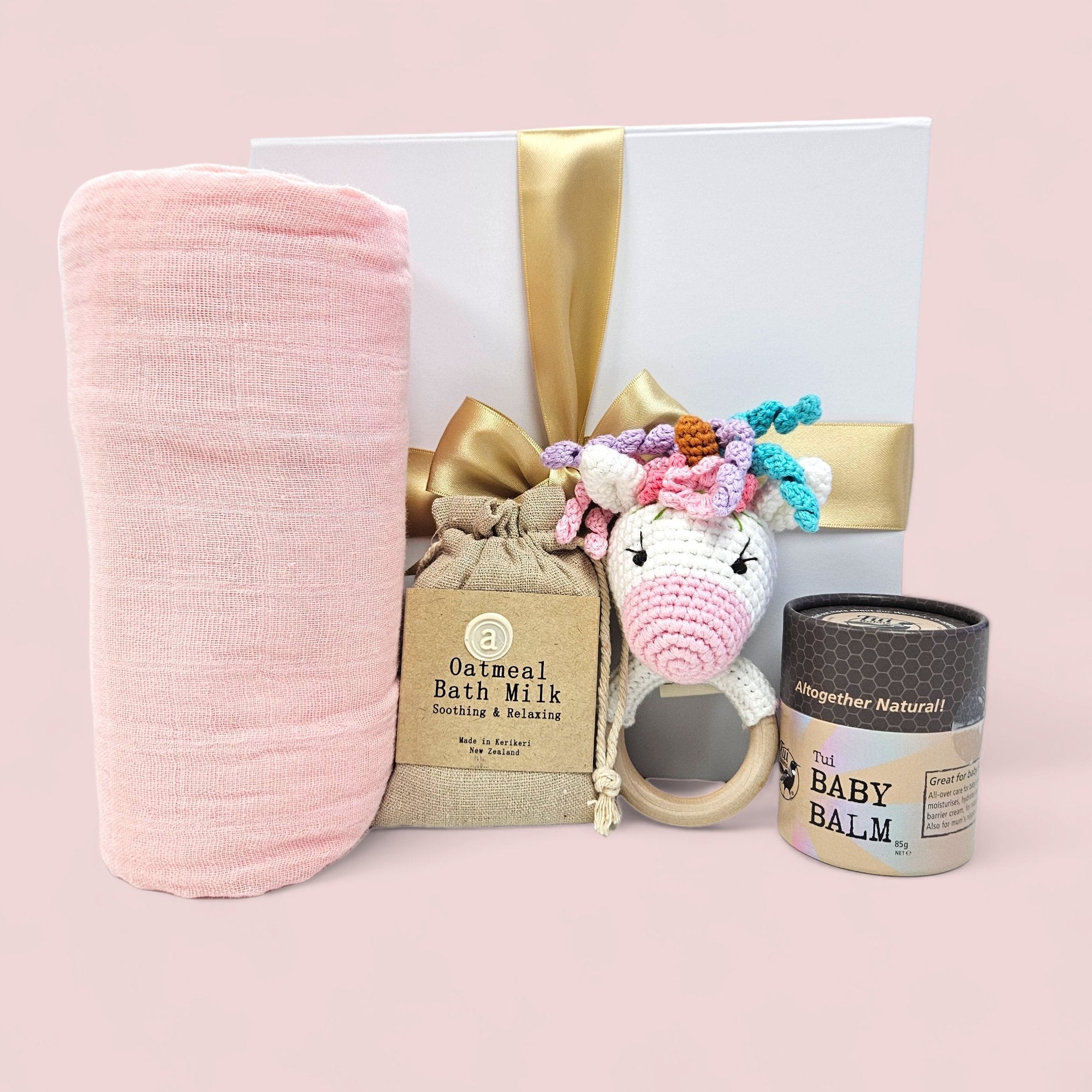 Cuddly Baby - Unicorn Gift Box with baby essentials: bath milk, muslin swaddle, rattle, and soothing balm for newborns.
