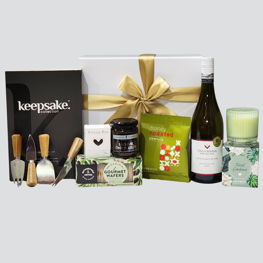 Elegant Home gift box featuring a scented candle, cheese knife set, wine, gourmet snacks, and a balsamic onion relish.