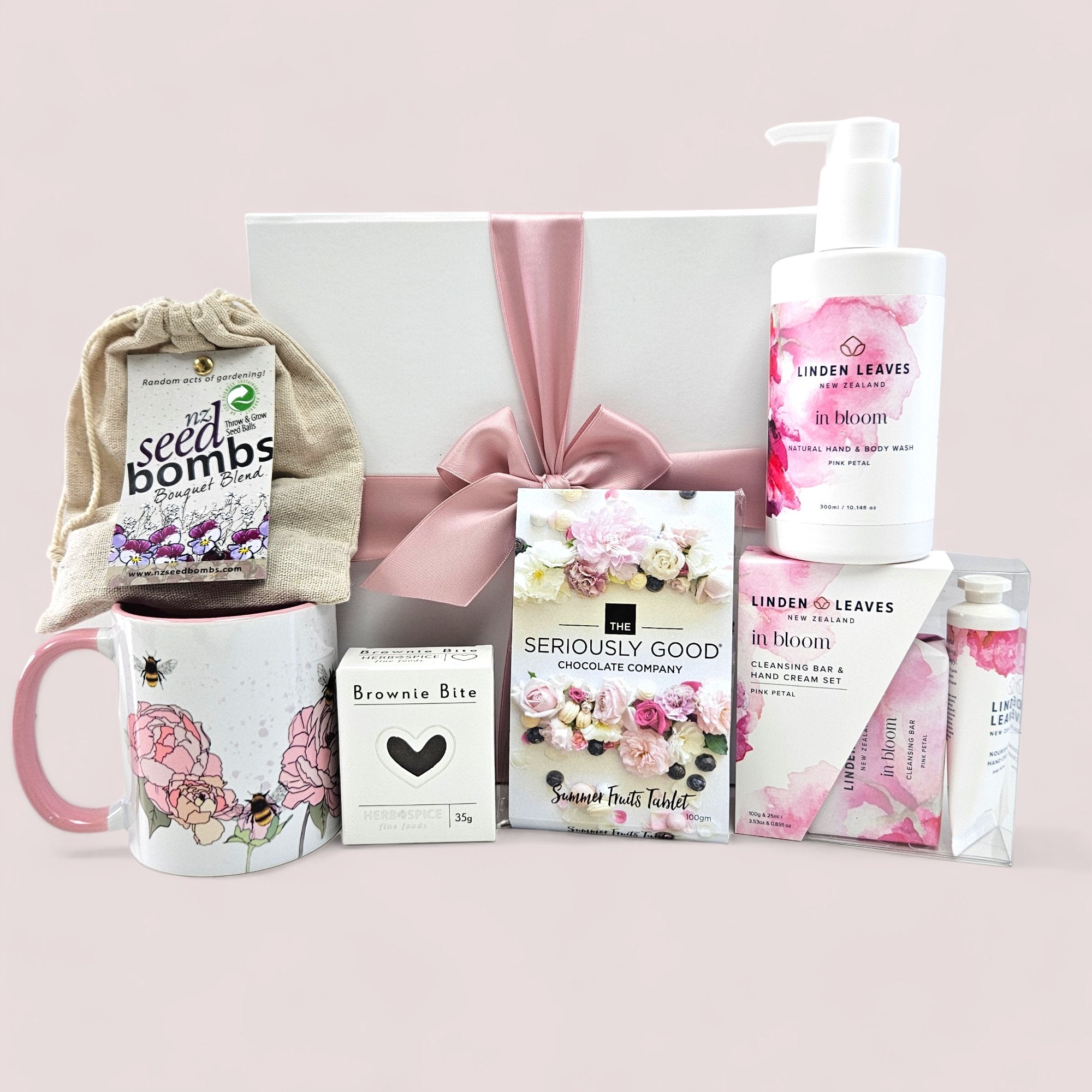 Elegant gift box featuring flowers, gourmet chocolates, and luxurious pampering items for a special occasion.