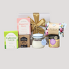 Elegant gift box featuring comforting items for recovery, including soothing teas, a lavender balm, hot chocolate, and an aromatherapy candle.