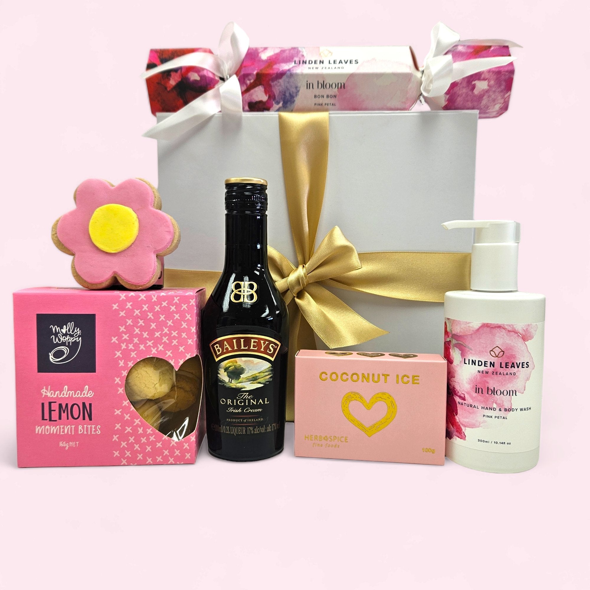 Luxurious pink gift box for her, featuring Baileys, hand creams, coconut ice, lemon shortbreads, and more, elegantly wrapped.