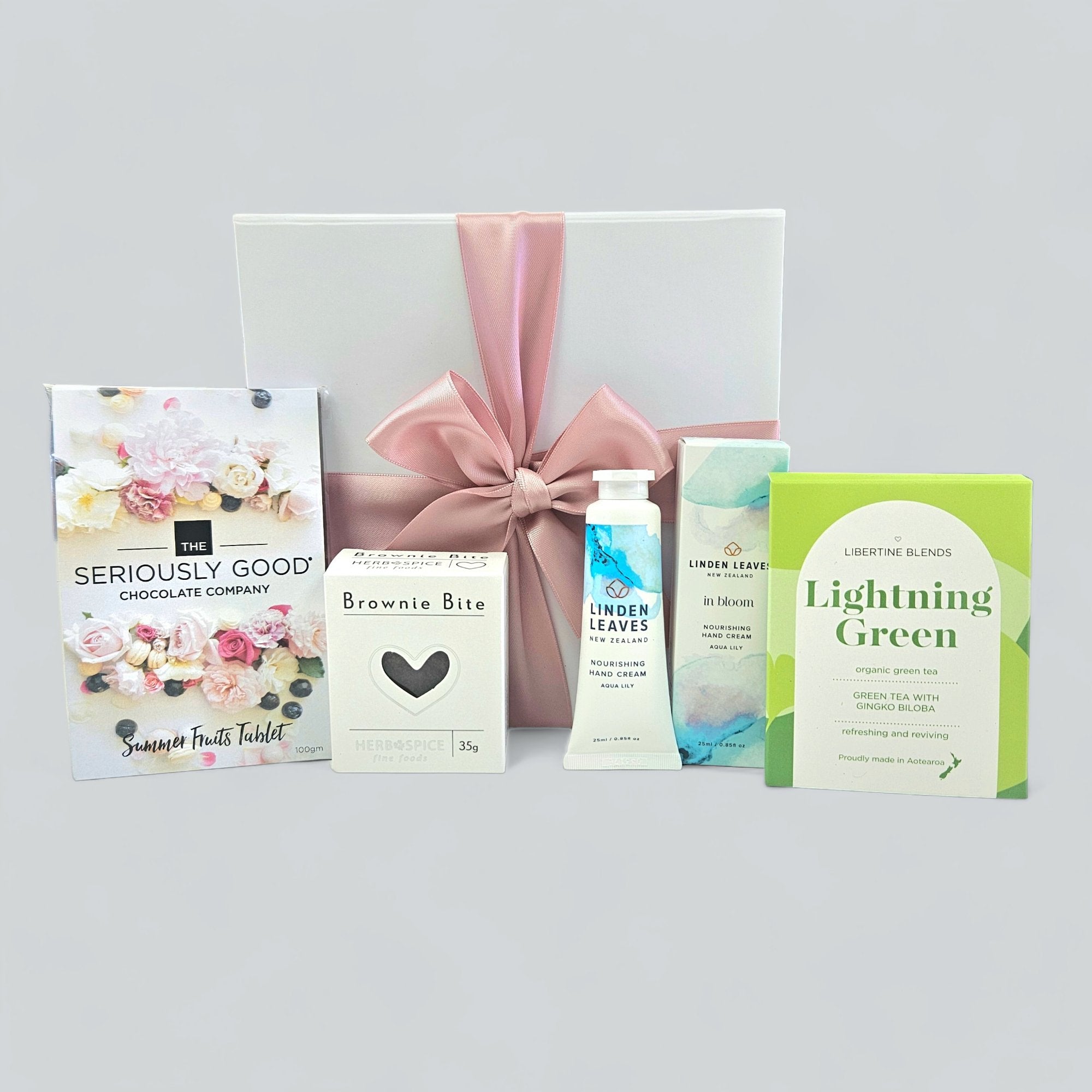 Elegant green gift box filled with gourmet treats, hand cream, and revitalizing tea for a luxurious gifting experience.