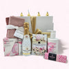 Gift box filled with pink treats including chocolate, sparkling wine, hand wash, and more, perfect for special occasions.