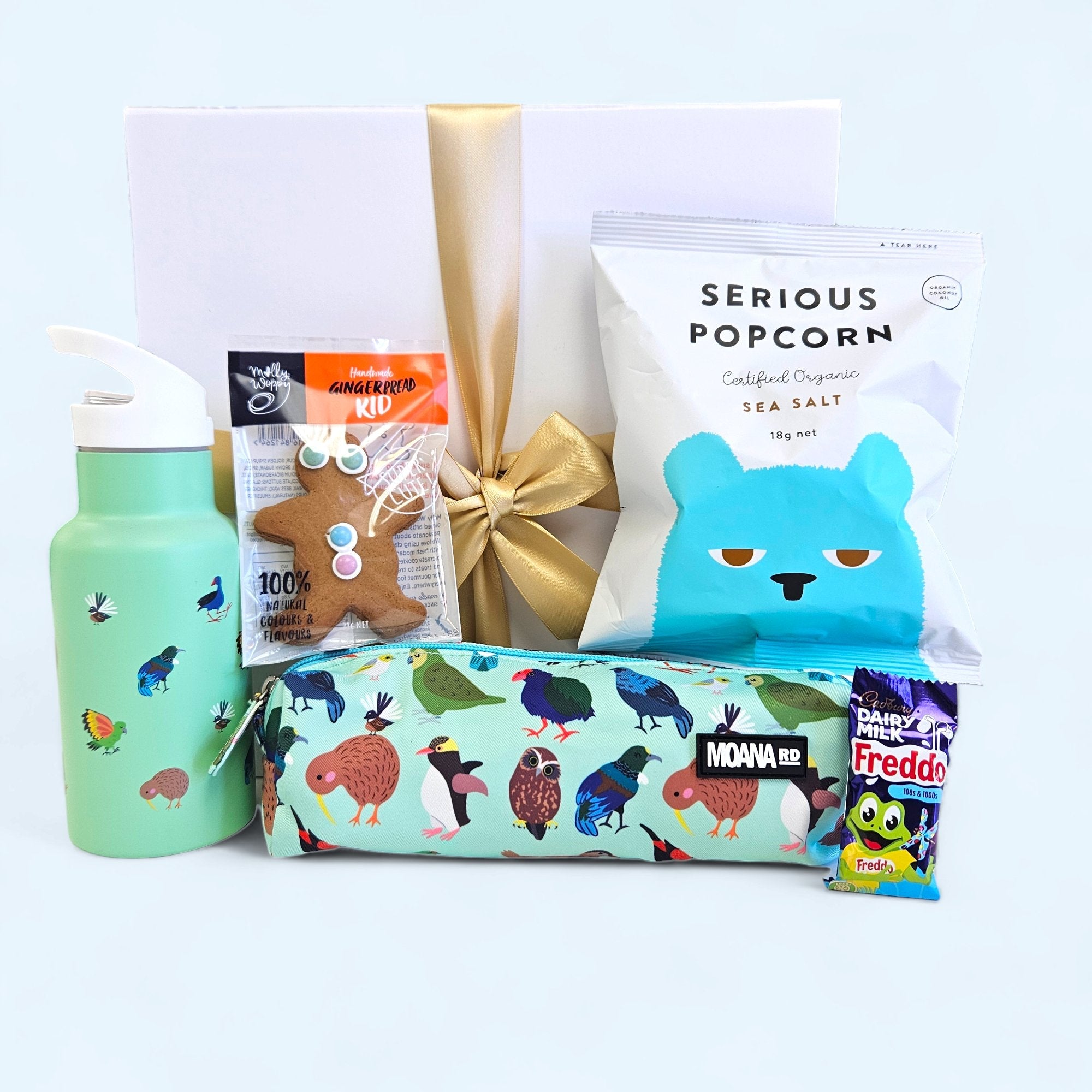 Gift box for kids in green filled with popcorn, biscuits, a pencil case, drink bottle, and elegant ribbon closure.