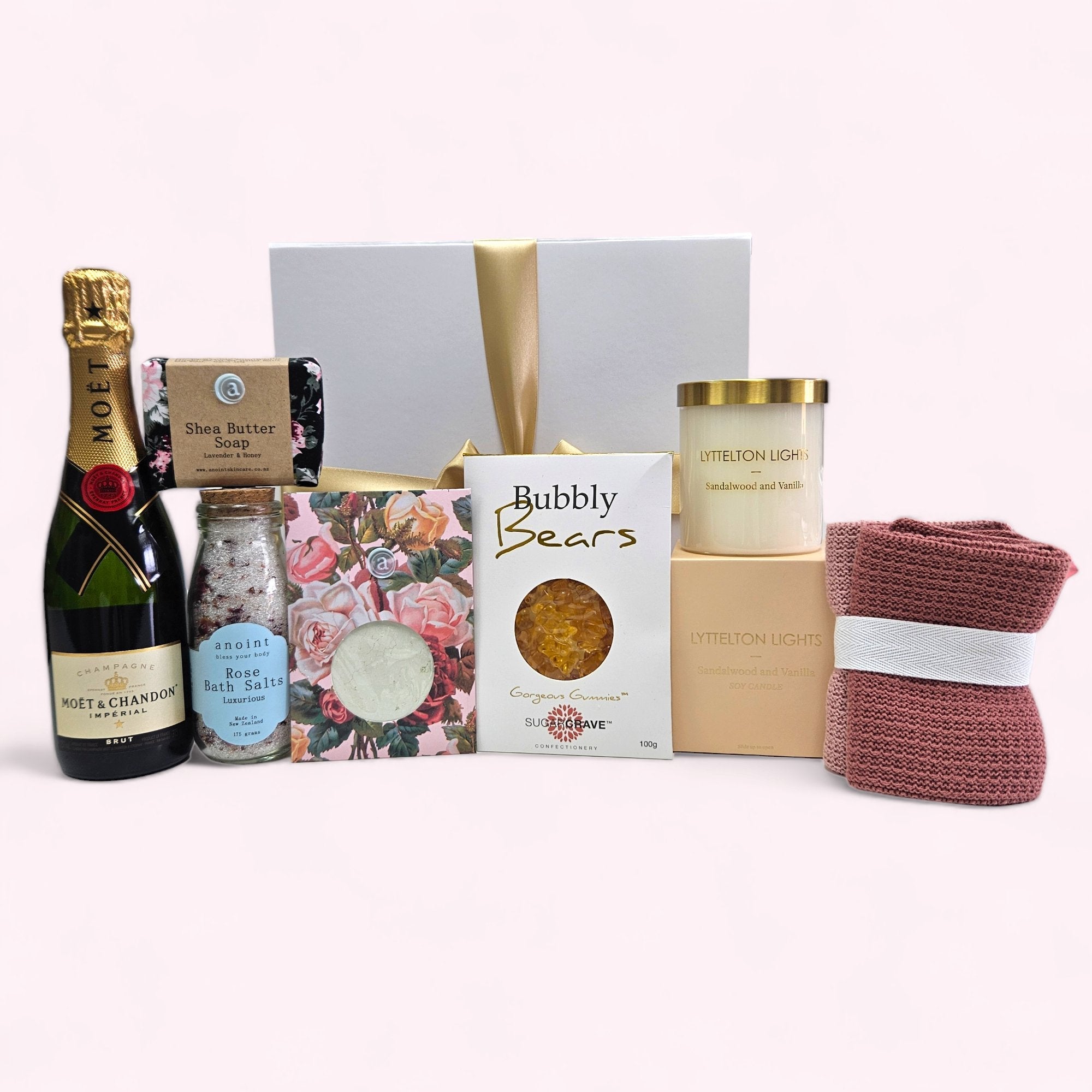 Elegant gift box featuring luxury bath salts, bubbly bears, facecloths, candle, face mask, and soap for ultimate pampering.