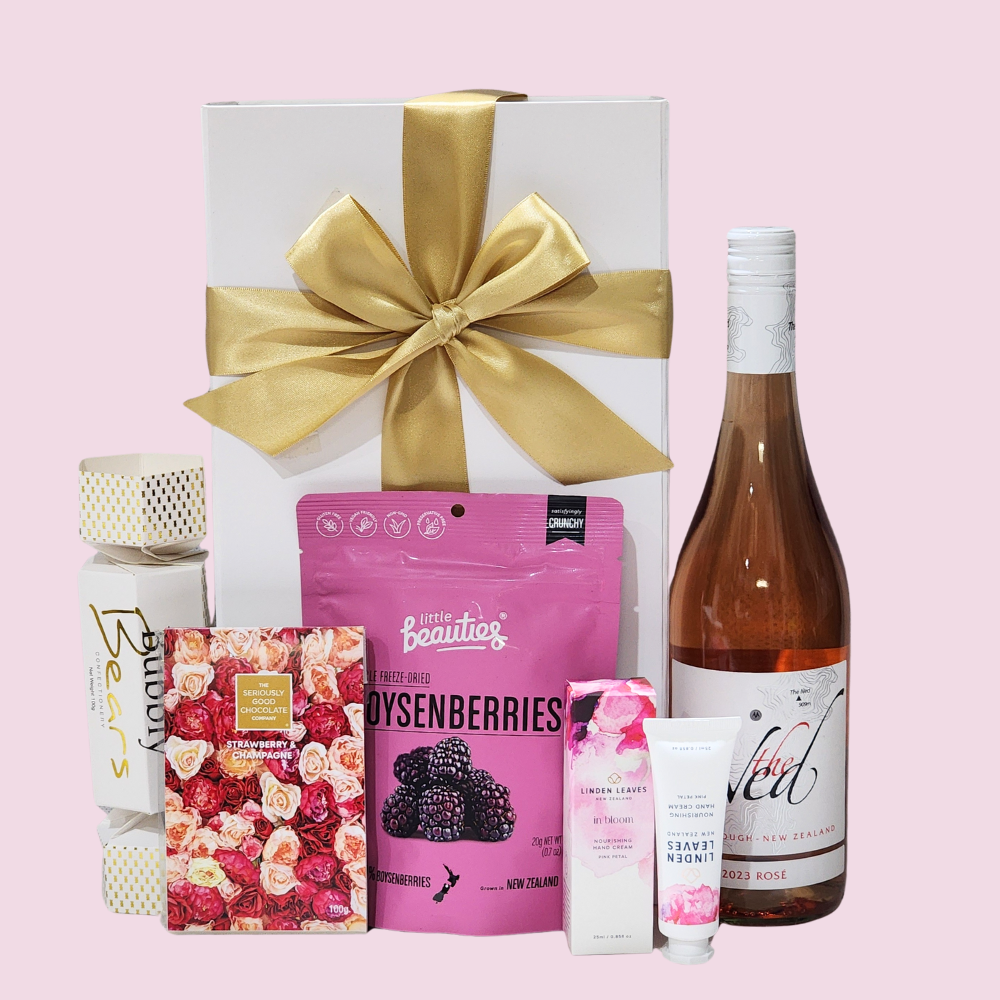 Elegant pink gift box filled with wine, freeze-dried berries, chocolate, hand cream, and delightful snacks for any occasion.
