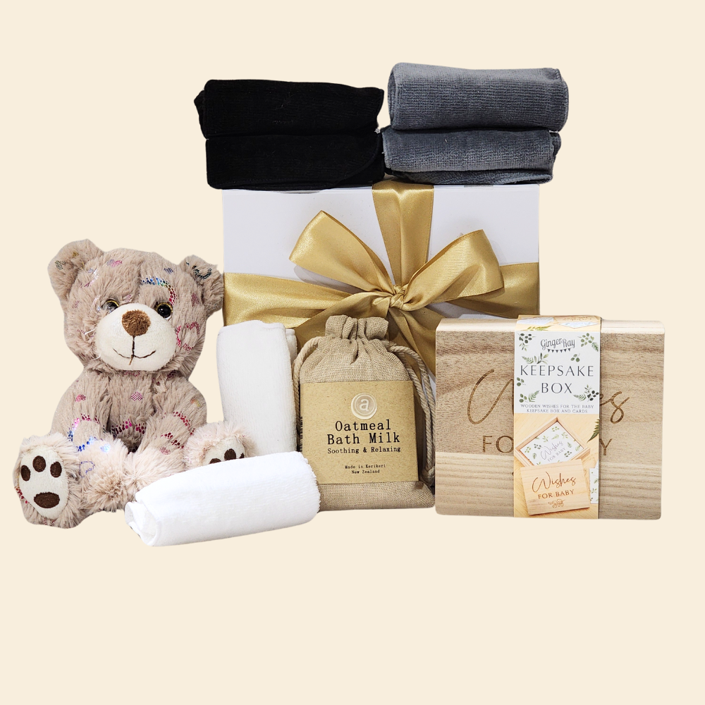 Elegant Baby Shower Wishes gift box filled with essentials, including a bib, plush toy, bath milk, and keepsake wish cards.